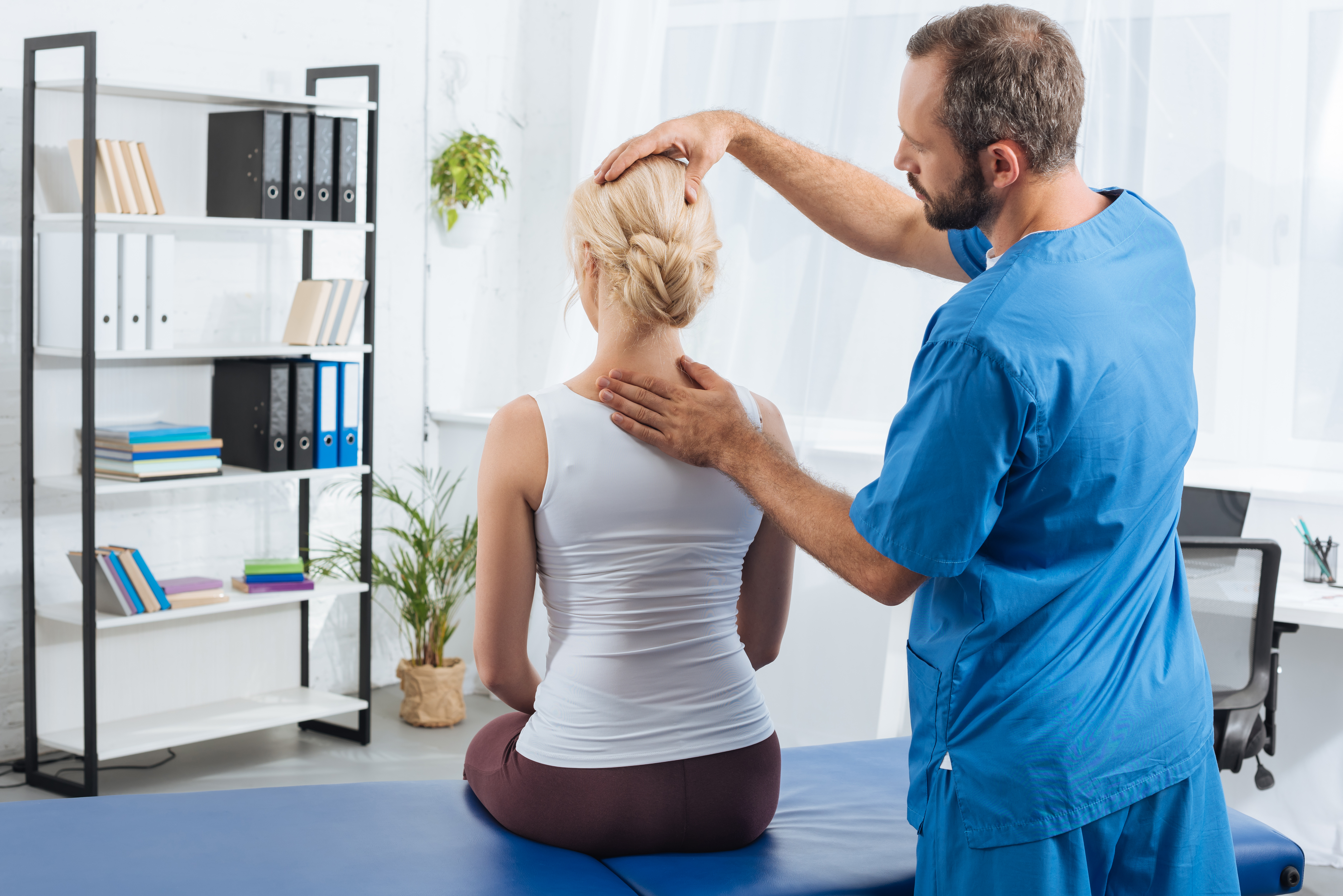 physiotherapist doing massage to woman on massage table in hospital